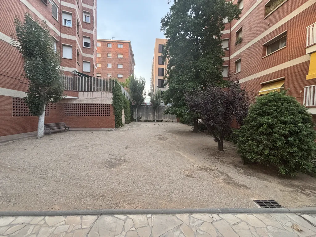 Patio comunitario antes de la reforma: suelo de tierra entre los edificios